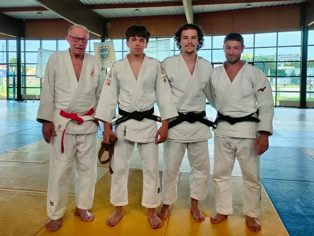 Jonas et Jegor, nouvelles ceintures noires, entourés de leurs professeurs sur le tatami du JCOV